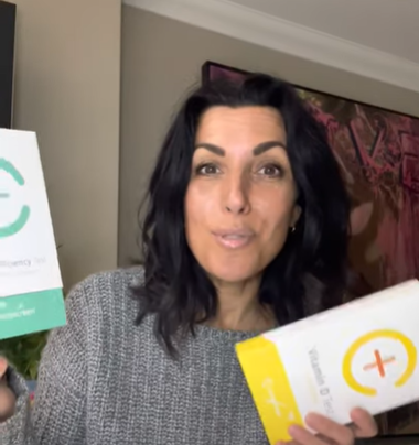 2 home test kits to try woman holding up a Vitamin D and Mineral deficiency kit