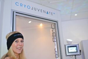 lady standing next to a -85 degree electric whole body cryotherapy chamber
