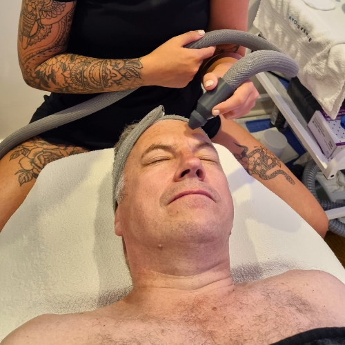 man laying on therapy bed and receiving cryotherapy on the face
